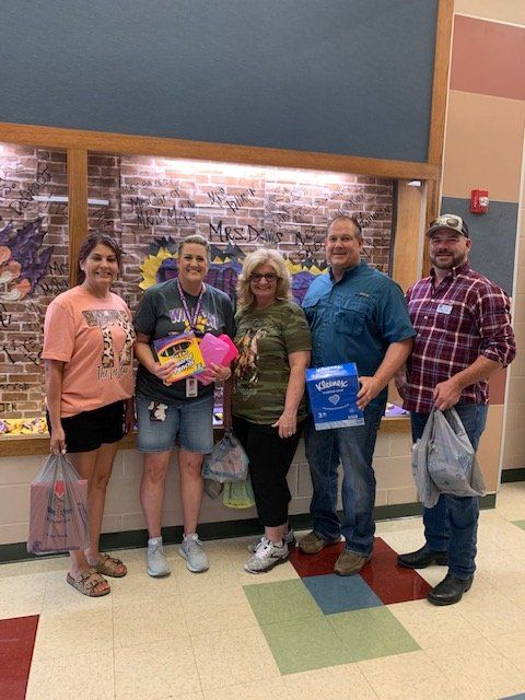 A group of people are posing for a picture in a hallway.