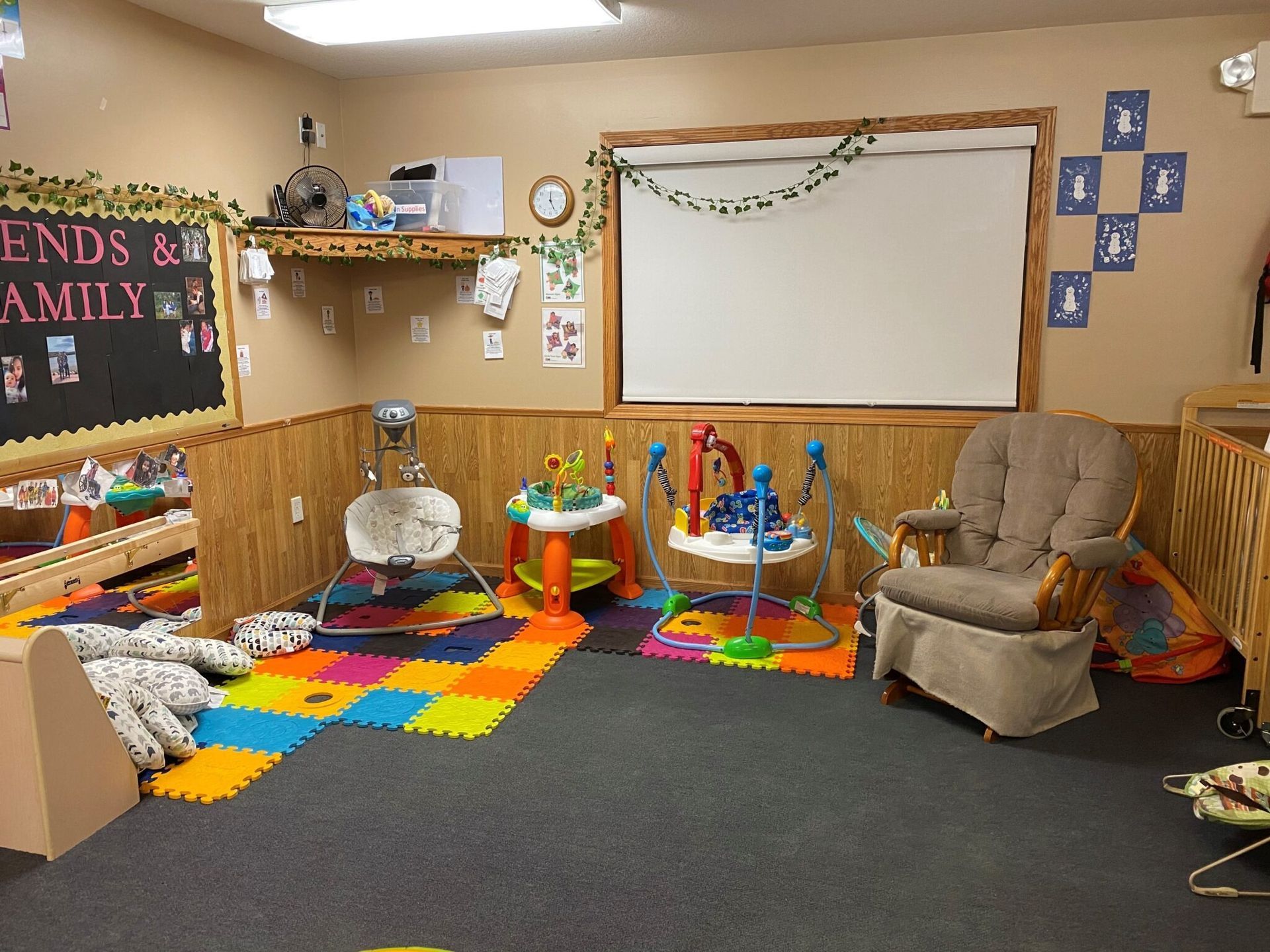 Playroom with baby toys, padded floor, and a comfy armchair.