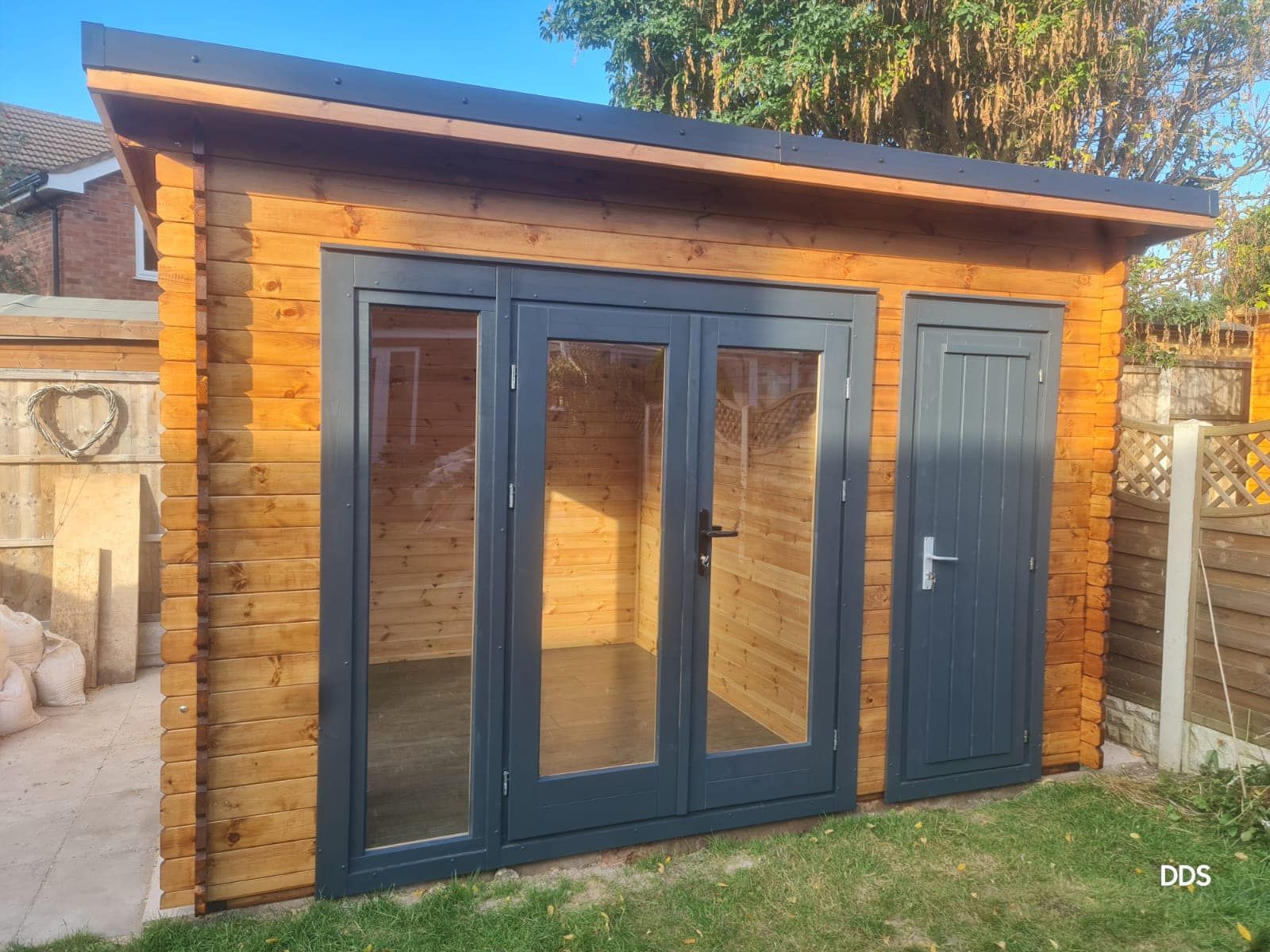 The inside of a green shed with the doors open.