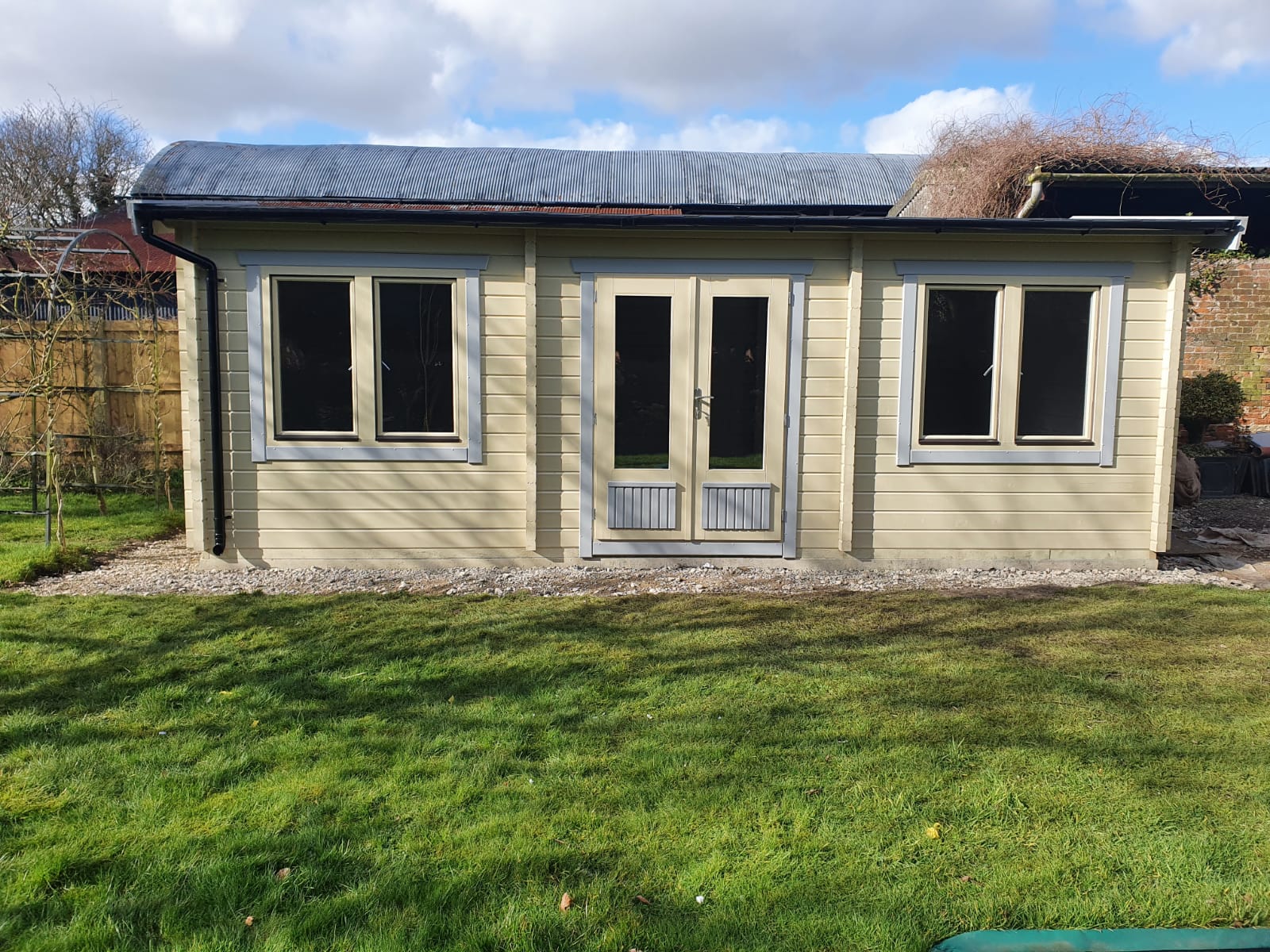 A small house is sitting in the middle of a lush green field.