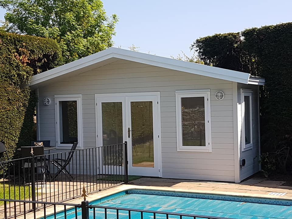 a small house is sitting next to a swimming pool .