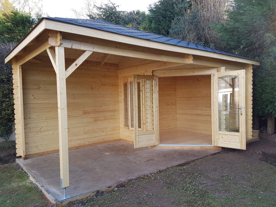 A small wooden house with a porch and a roof.