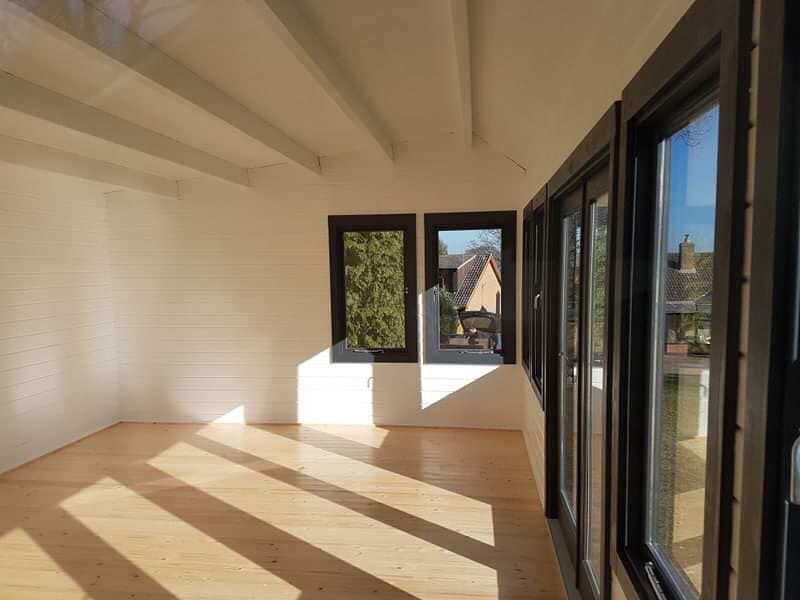 An empty room with a lot of windows and a wooden floor.