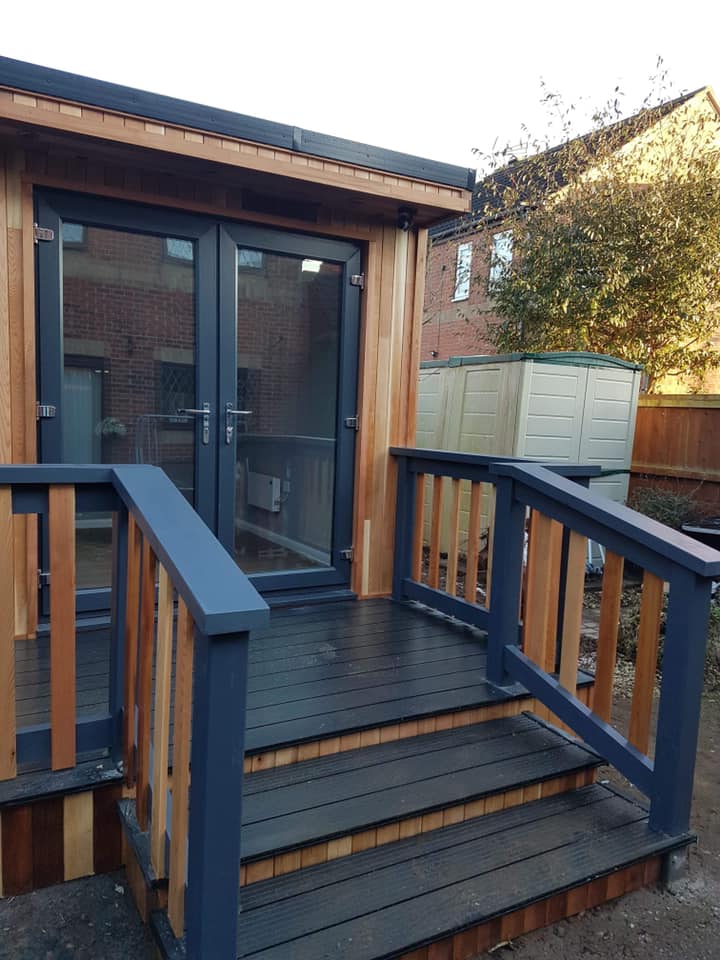 A wooden deck with stairs leading up to a house.