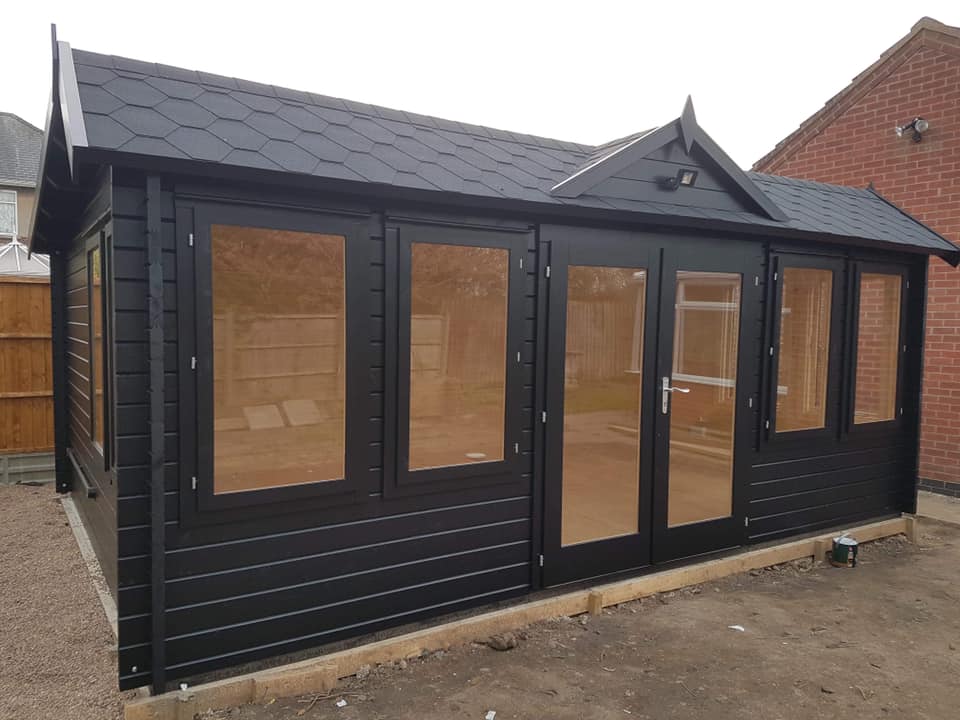 A black house with a roof and a lot of windows