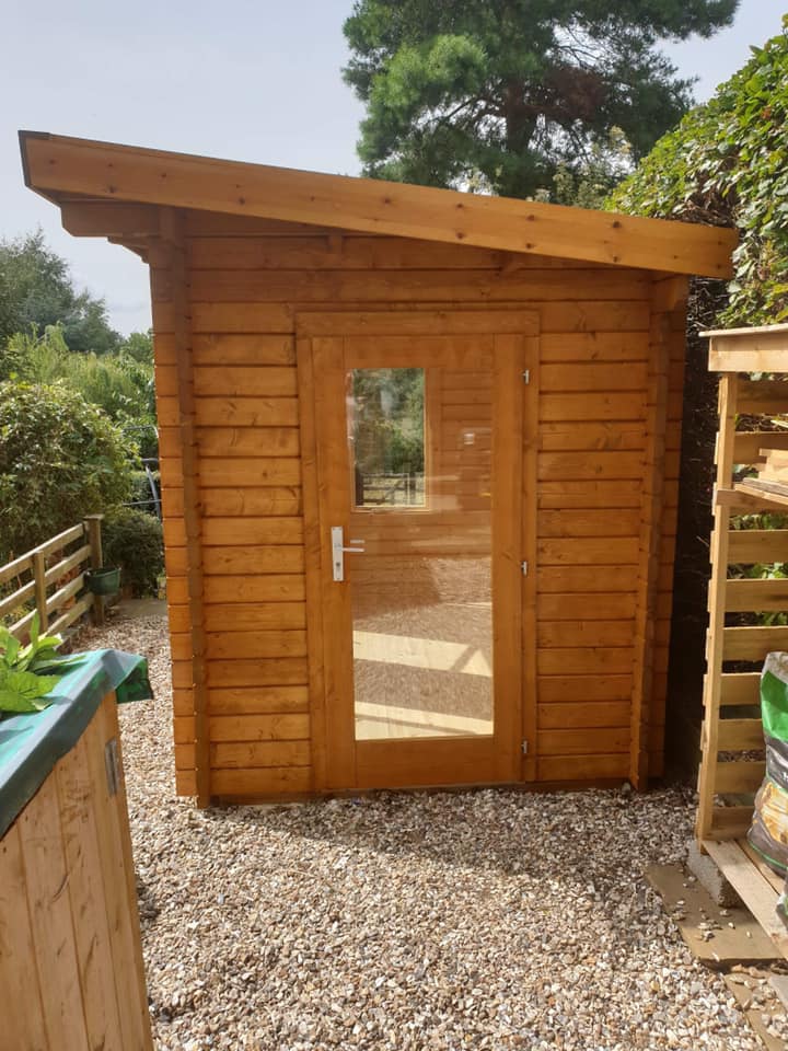 A small wooden shed with a glass door