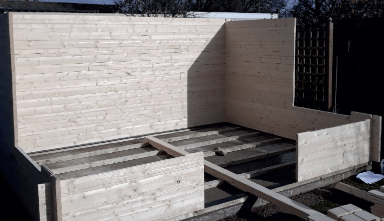 A wooden house is being built with a wooden floor.