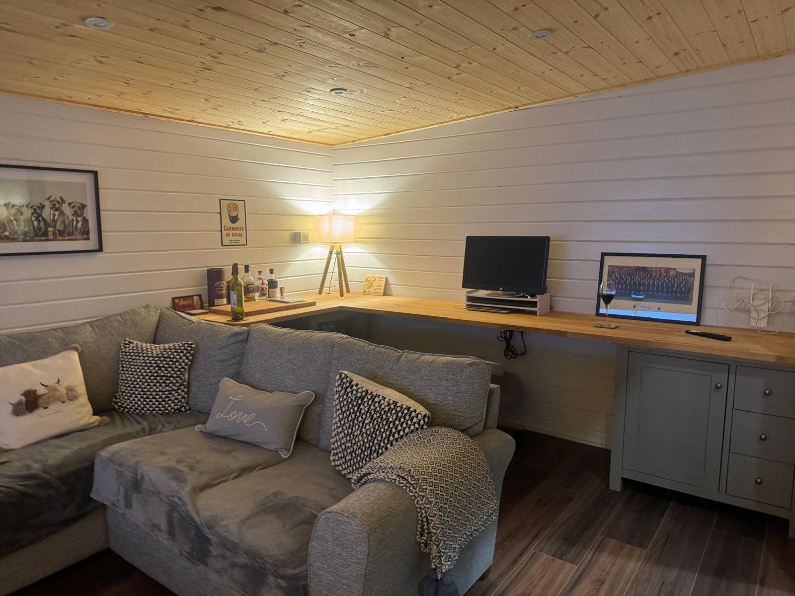 A living room with a couch and a desk with a computer on it.