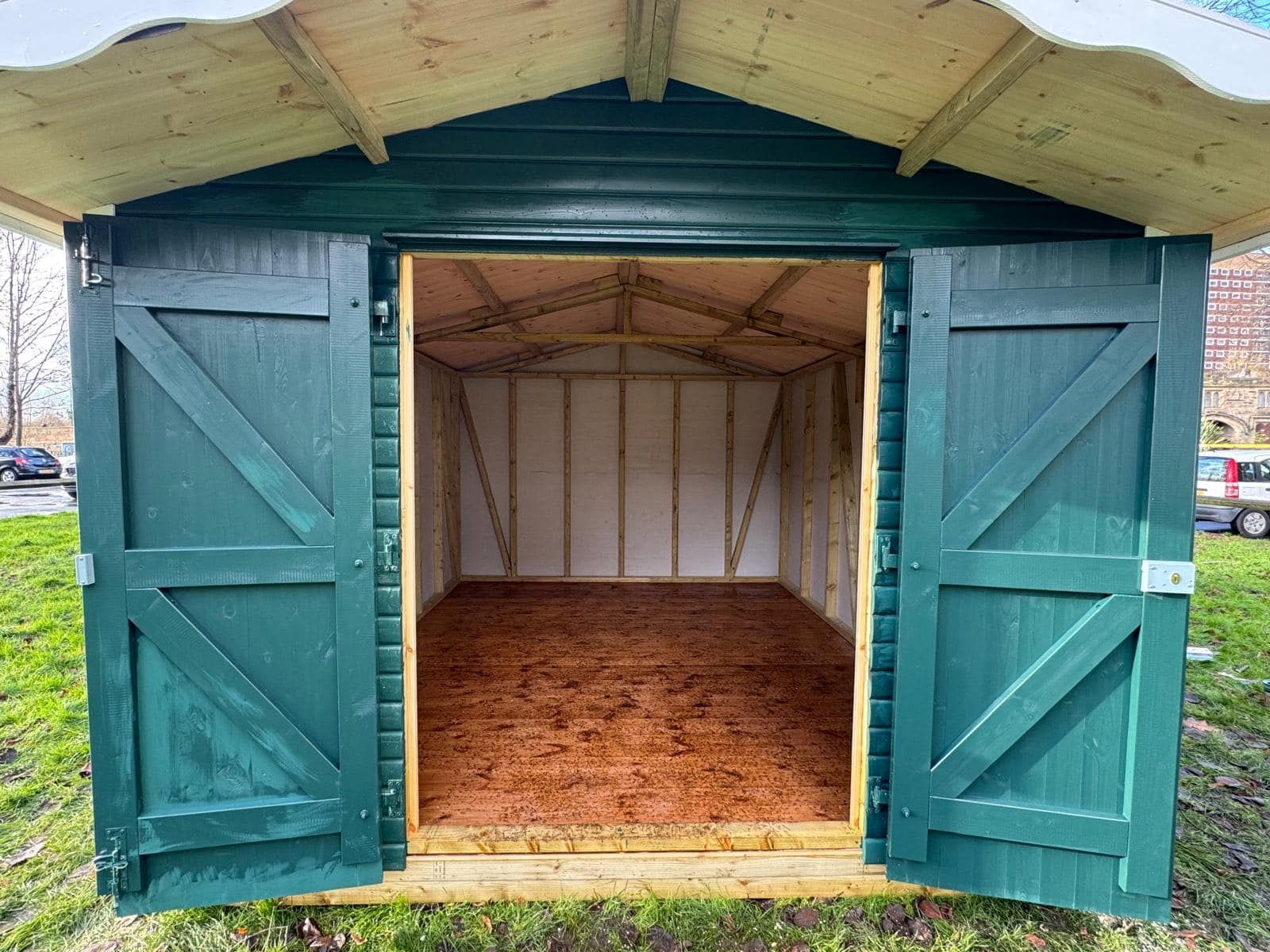 The inside of a green shed with the doors open.