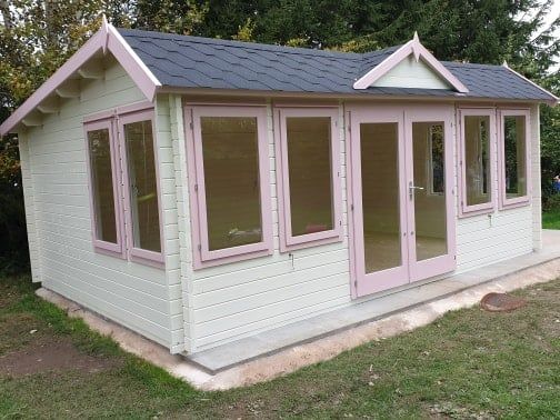 A small white house with pink windows and doors