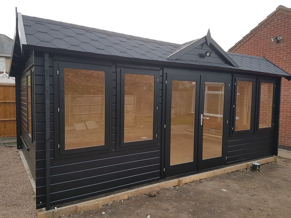 A black house with a roof and a lot of windows
