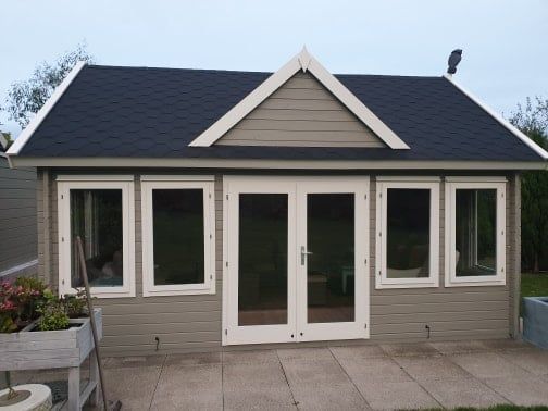 A small house with a black roof and white trim
