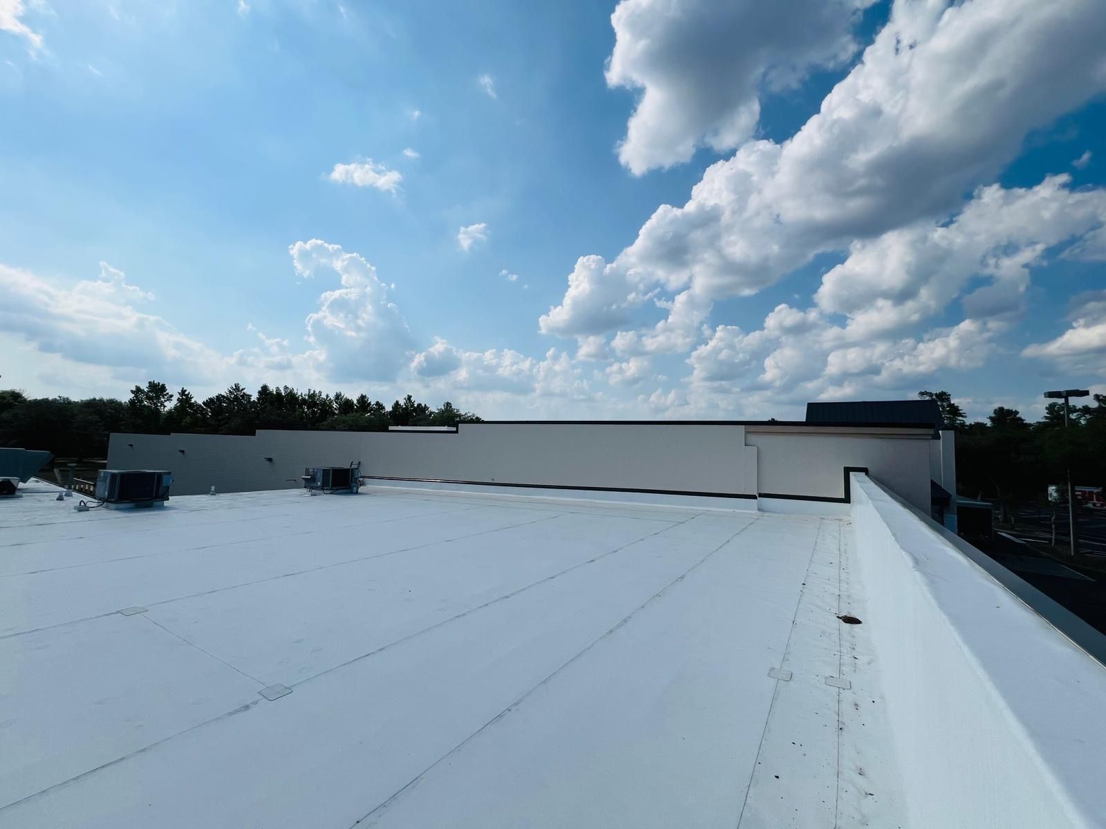 A white roof with a blue sky and clouds in the background.