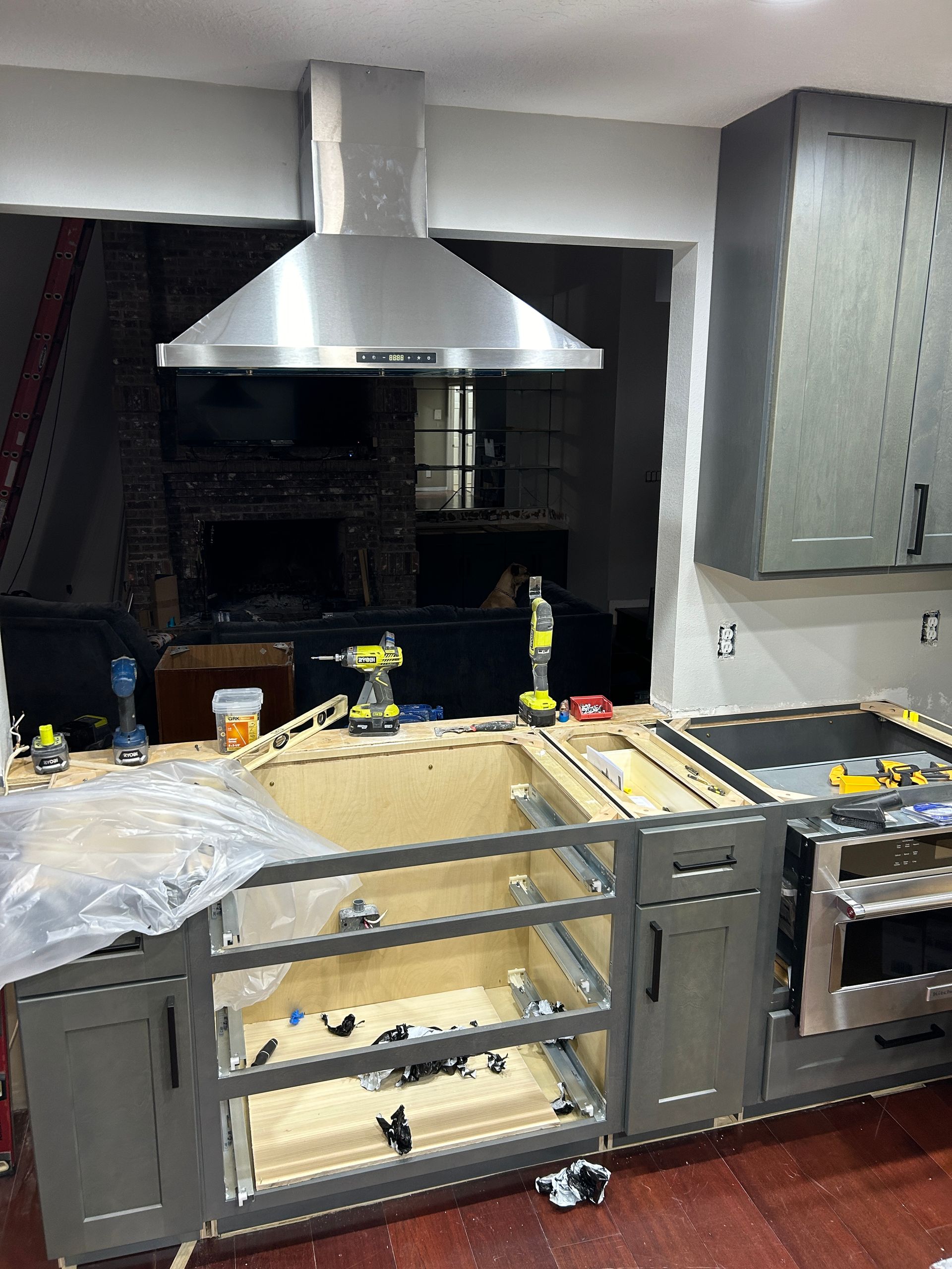 A kitchen is being remodeled with stainless steel cabinets and a stove.