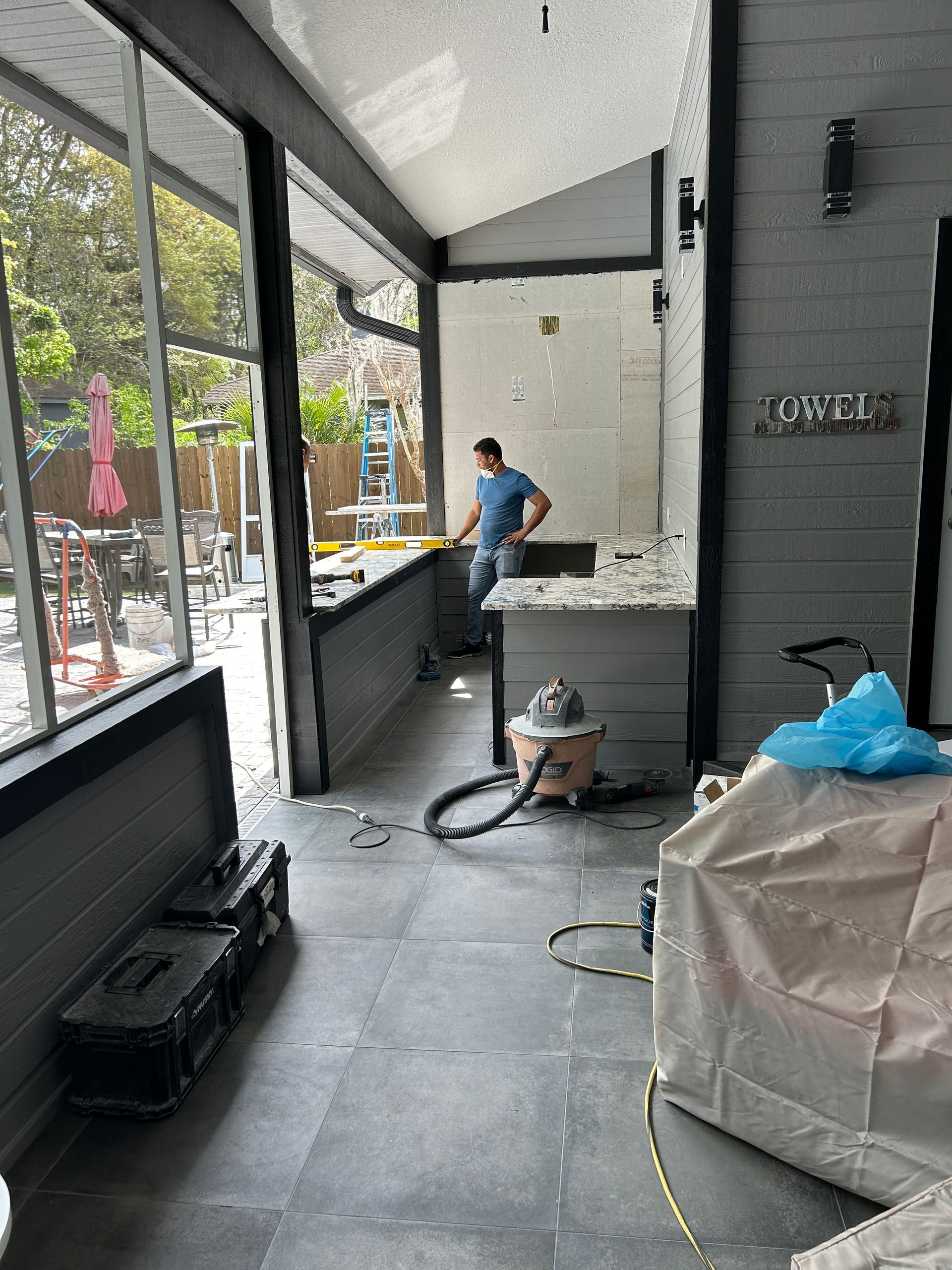 A man is standing in a room with a vacuum cleaner.