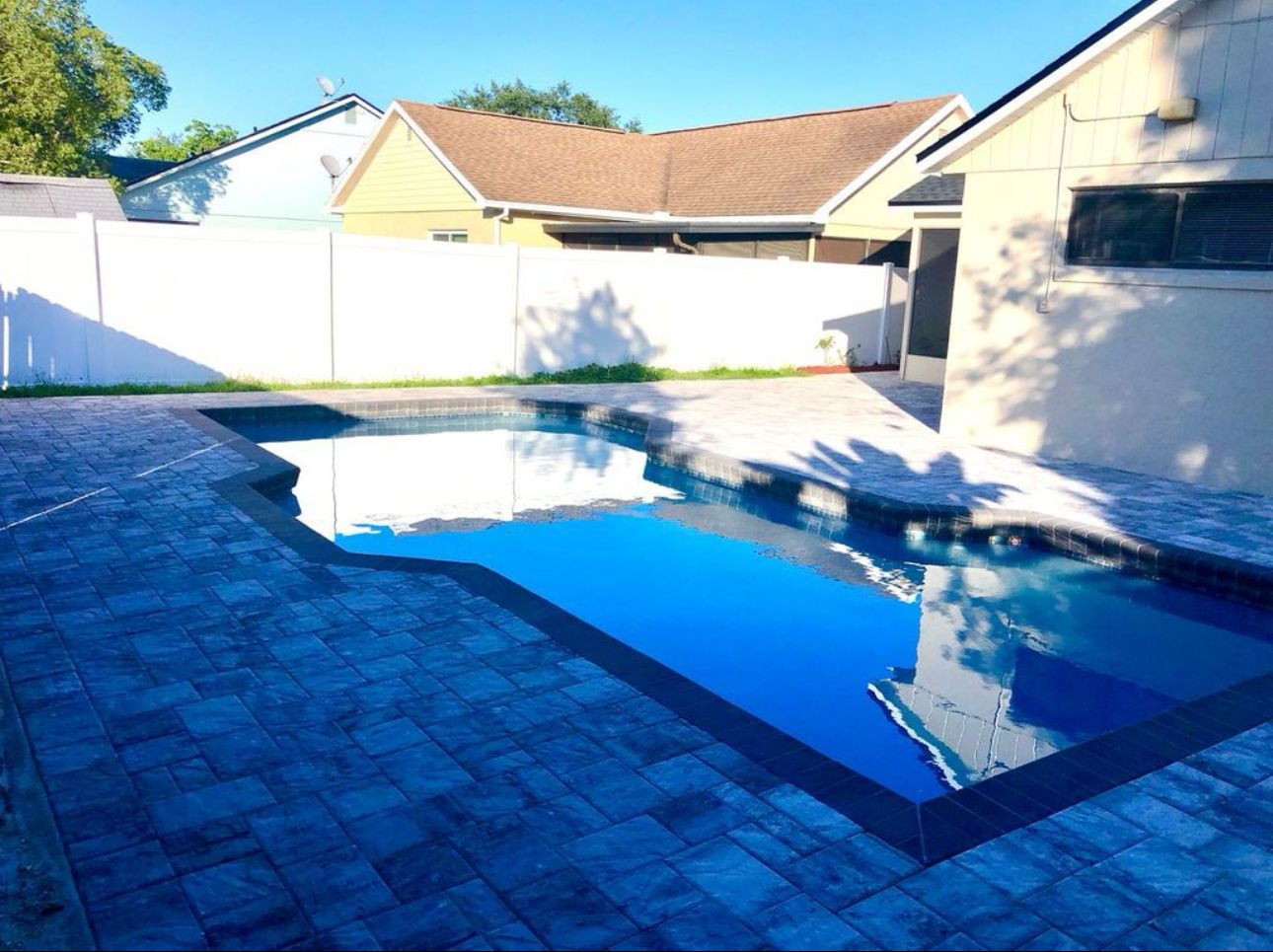 A large swimming pool in the backyard of a house