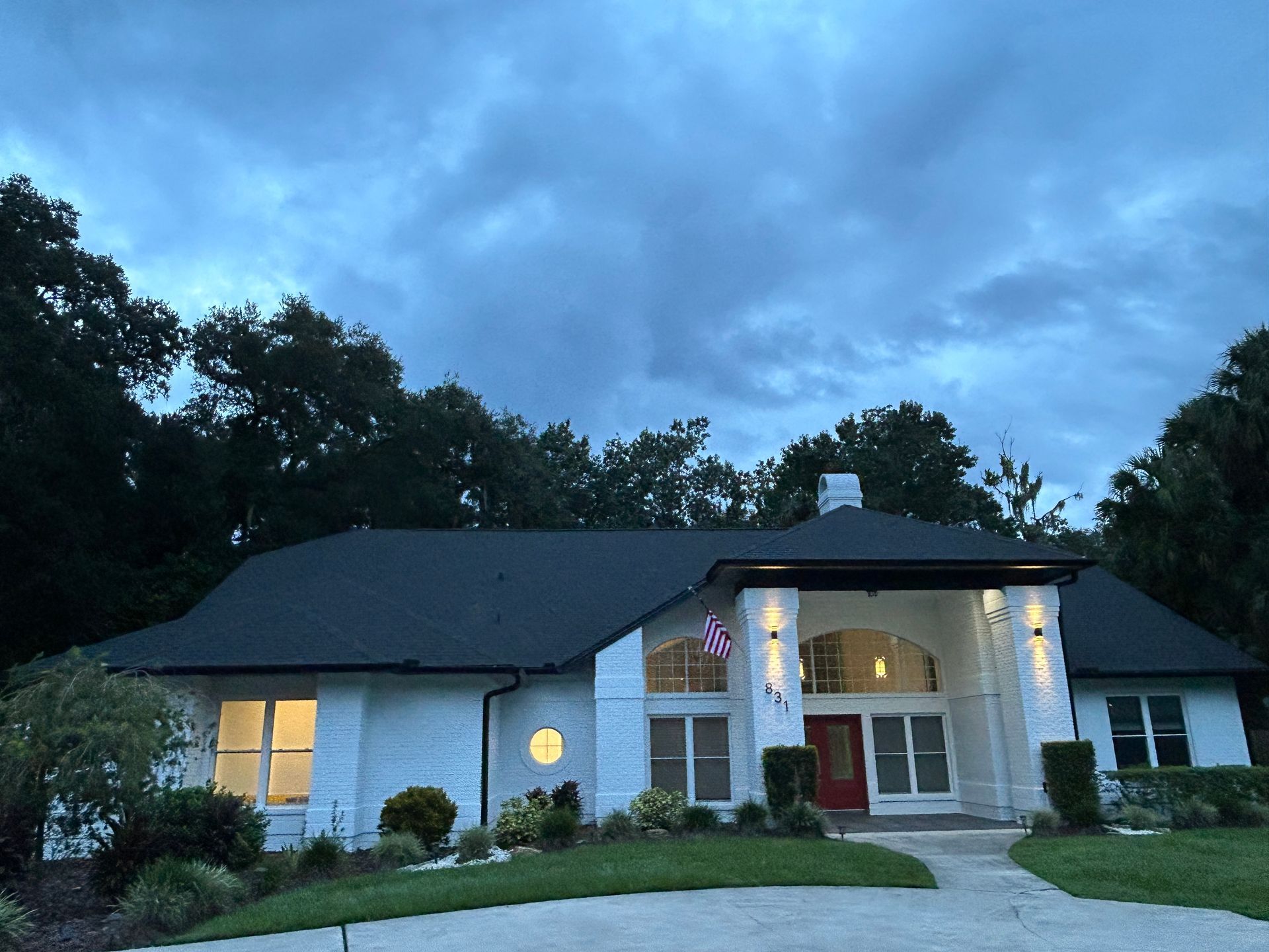 A white house with a black roof and a red door
