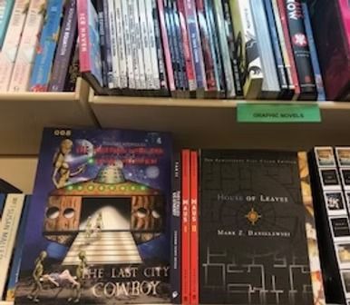 Shelves in a bookstore display various books, including