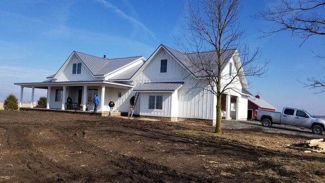 A large white house with a truck parked in front of it.
