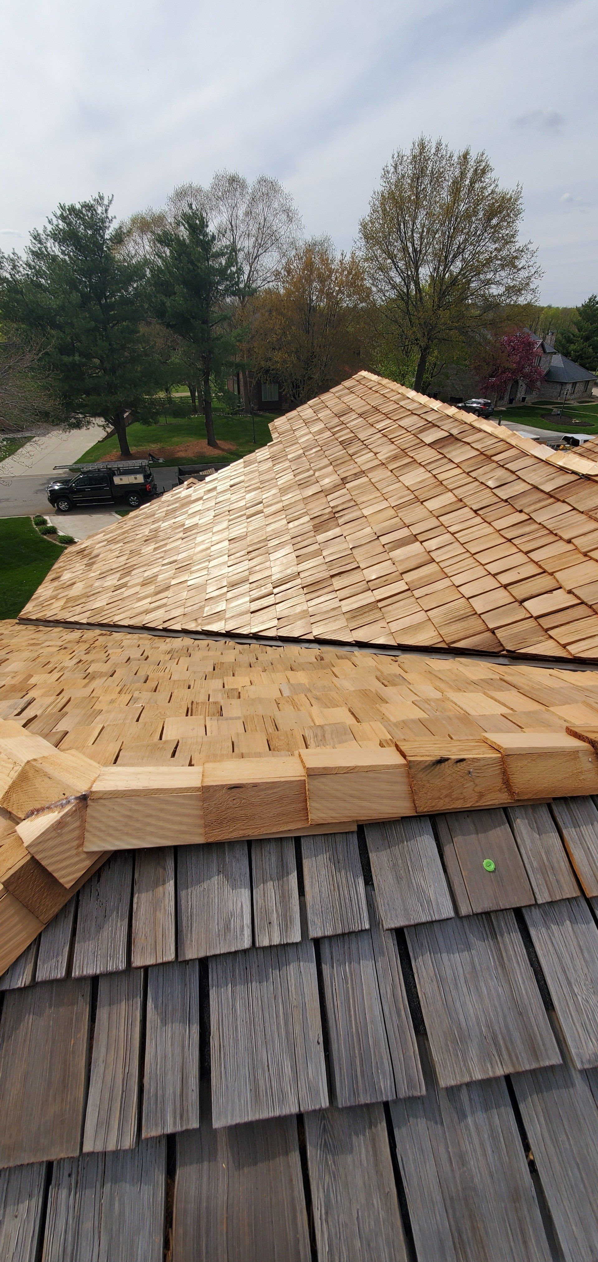 A wooden roof with shingles being installed on a house.