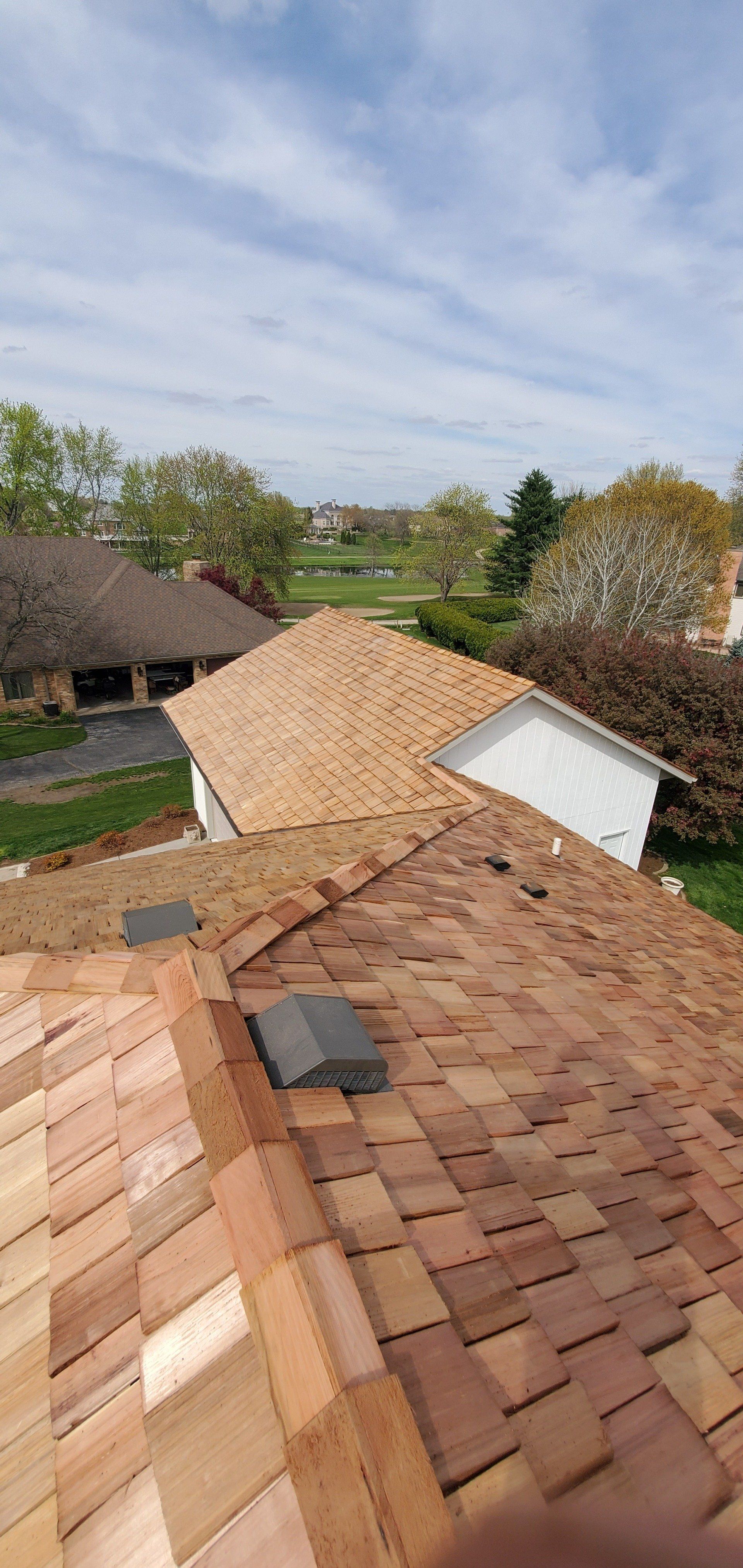 The roof of a house is being remodeled with wooden tiles.