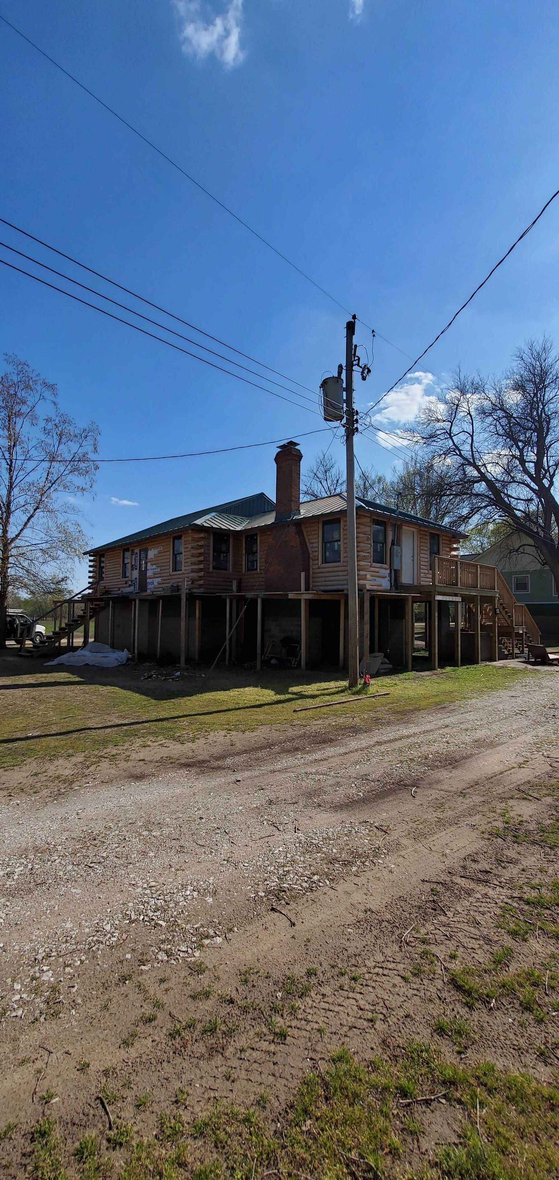 A large house is sitting on top of a dirt road.
