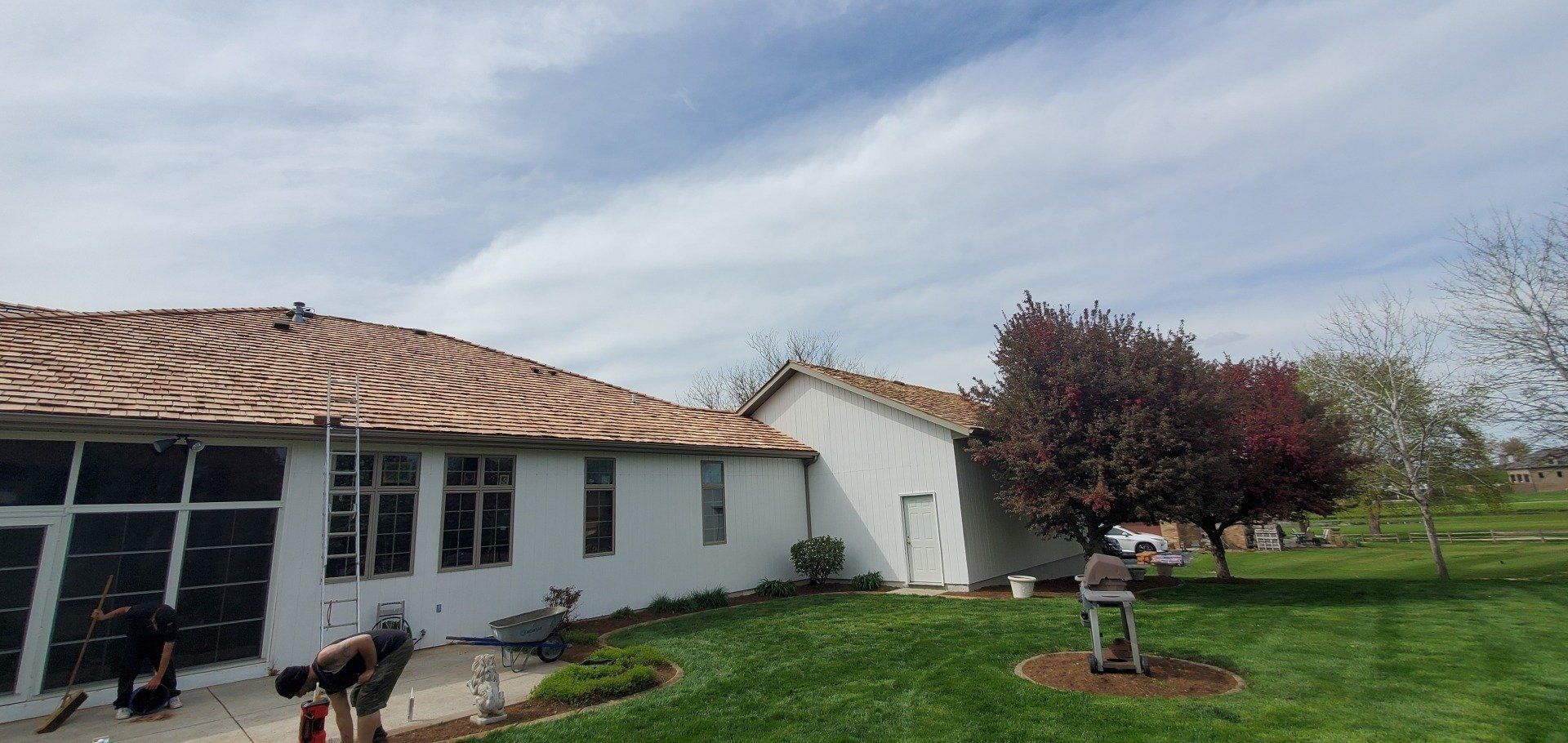 A group of people are working on the roof of a house.