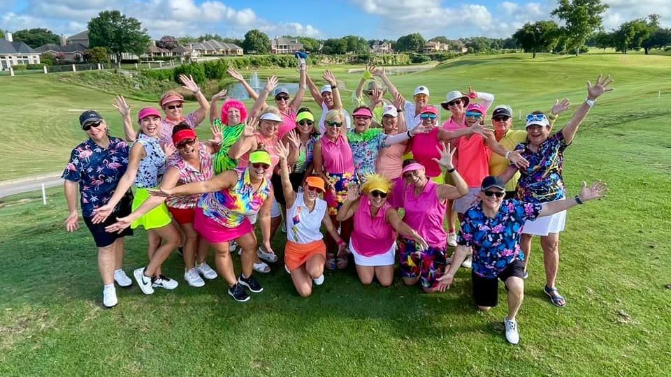 A group of people are posing for a picture on a golf course.