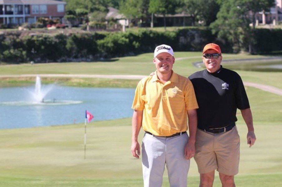 Two men standing next to each other on a golf course