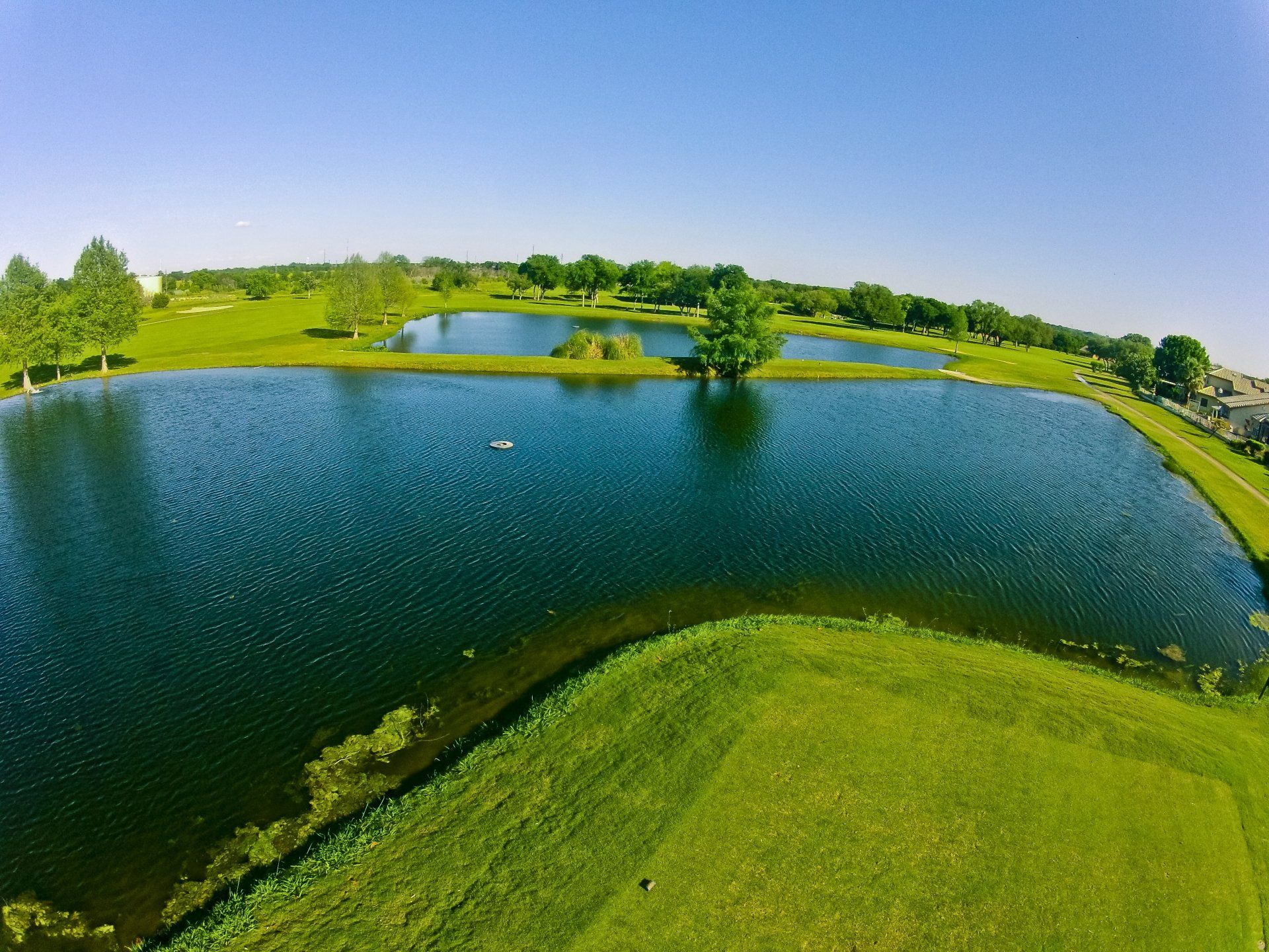 An aerial view of a golf course with a lake in the middle