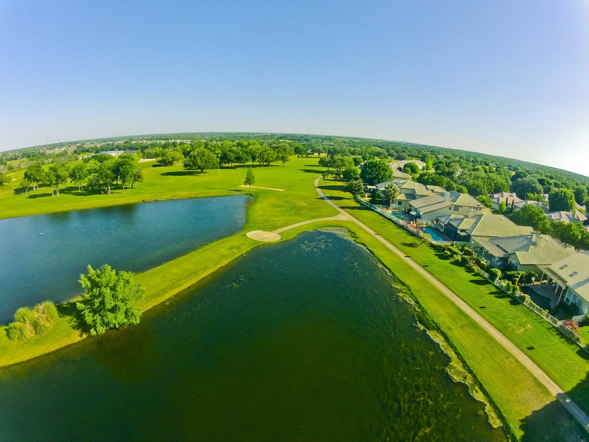 An aerial view of a golf course with a lake in the middle