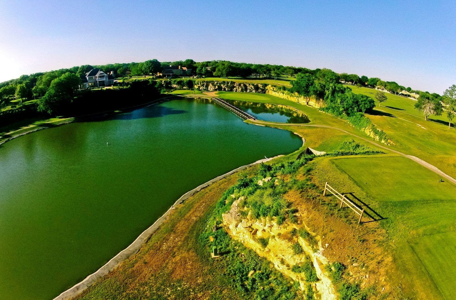 An aerial view of a golf course with a lake in the middle