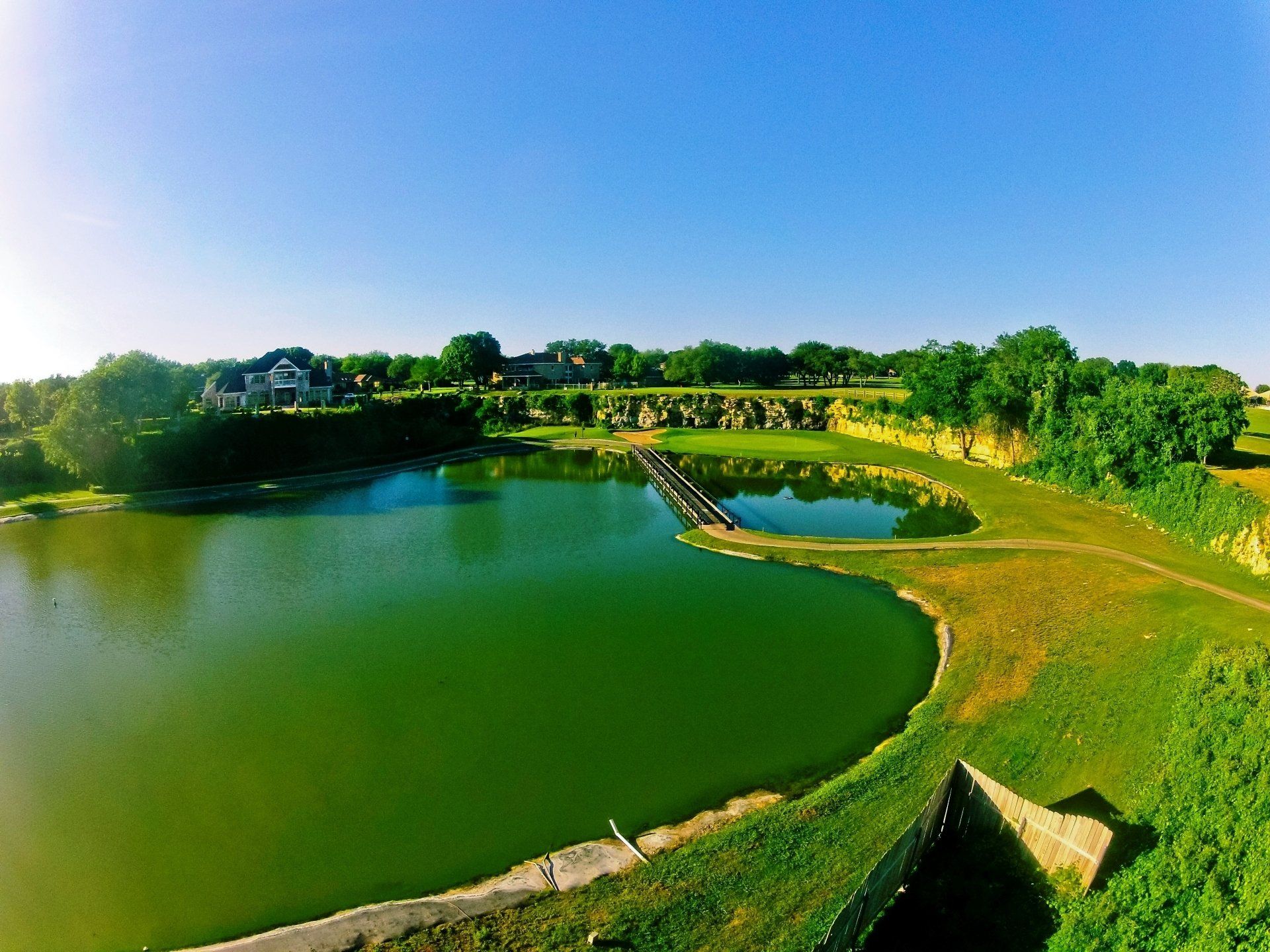 An aerial view of a lake surrounded by grass and trees.