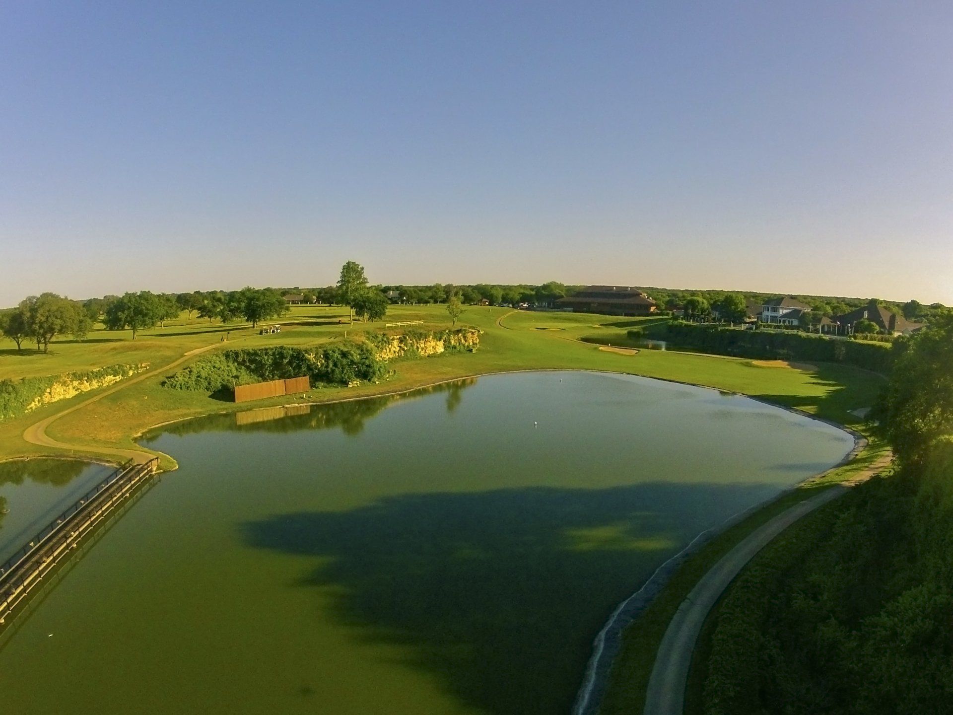 An aerial view of a golf course with a large lake in the middle