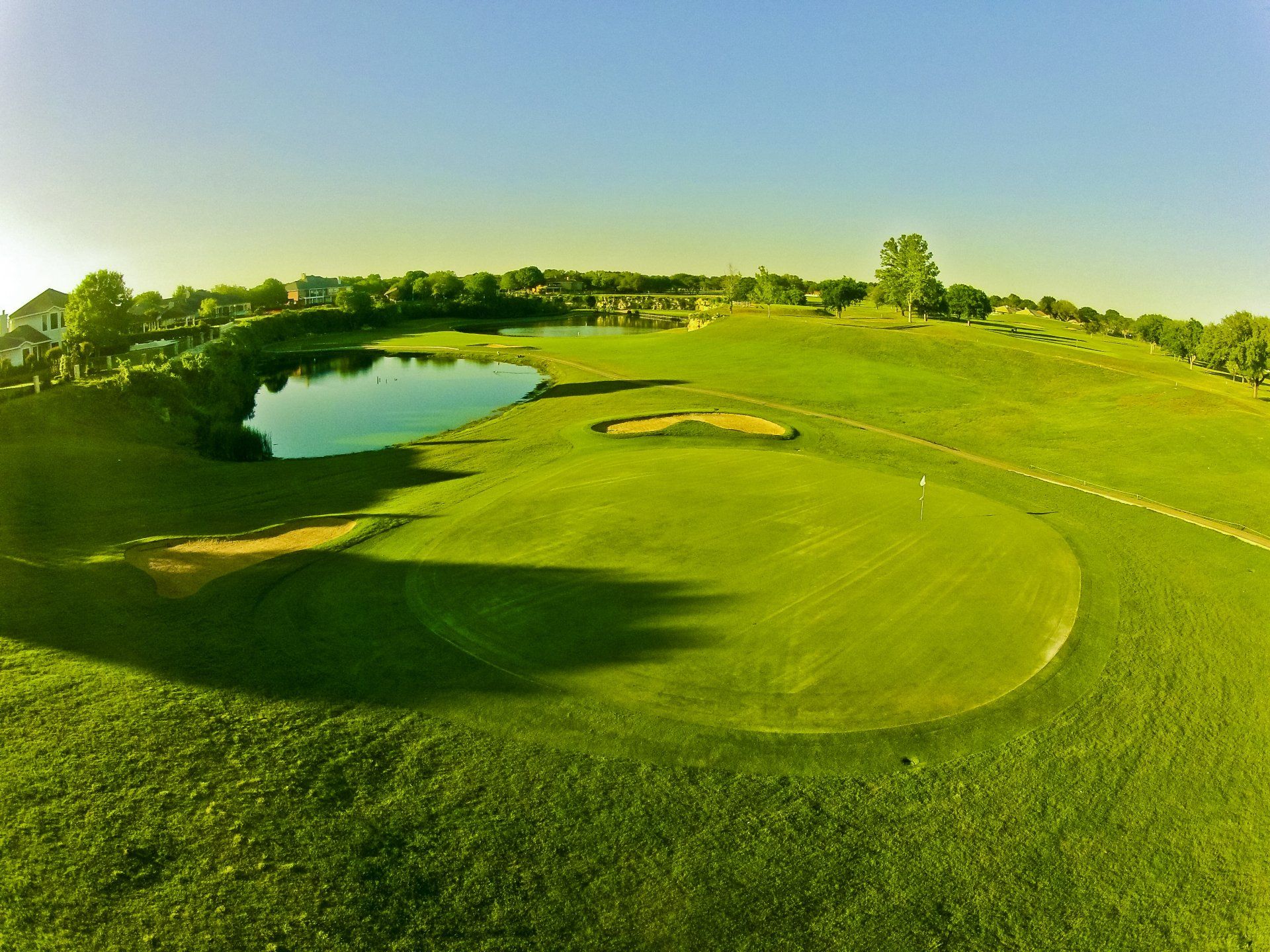 An aerial view of a golf course with a lake in the middle