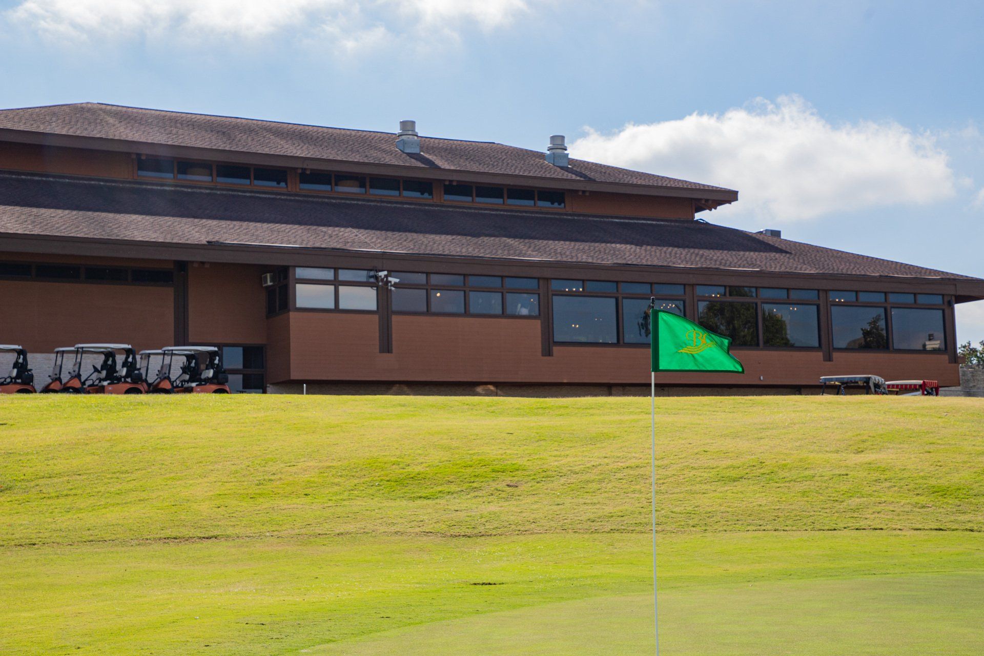 A large building with a green flag in front of it.