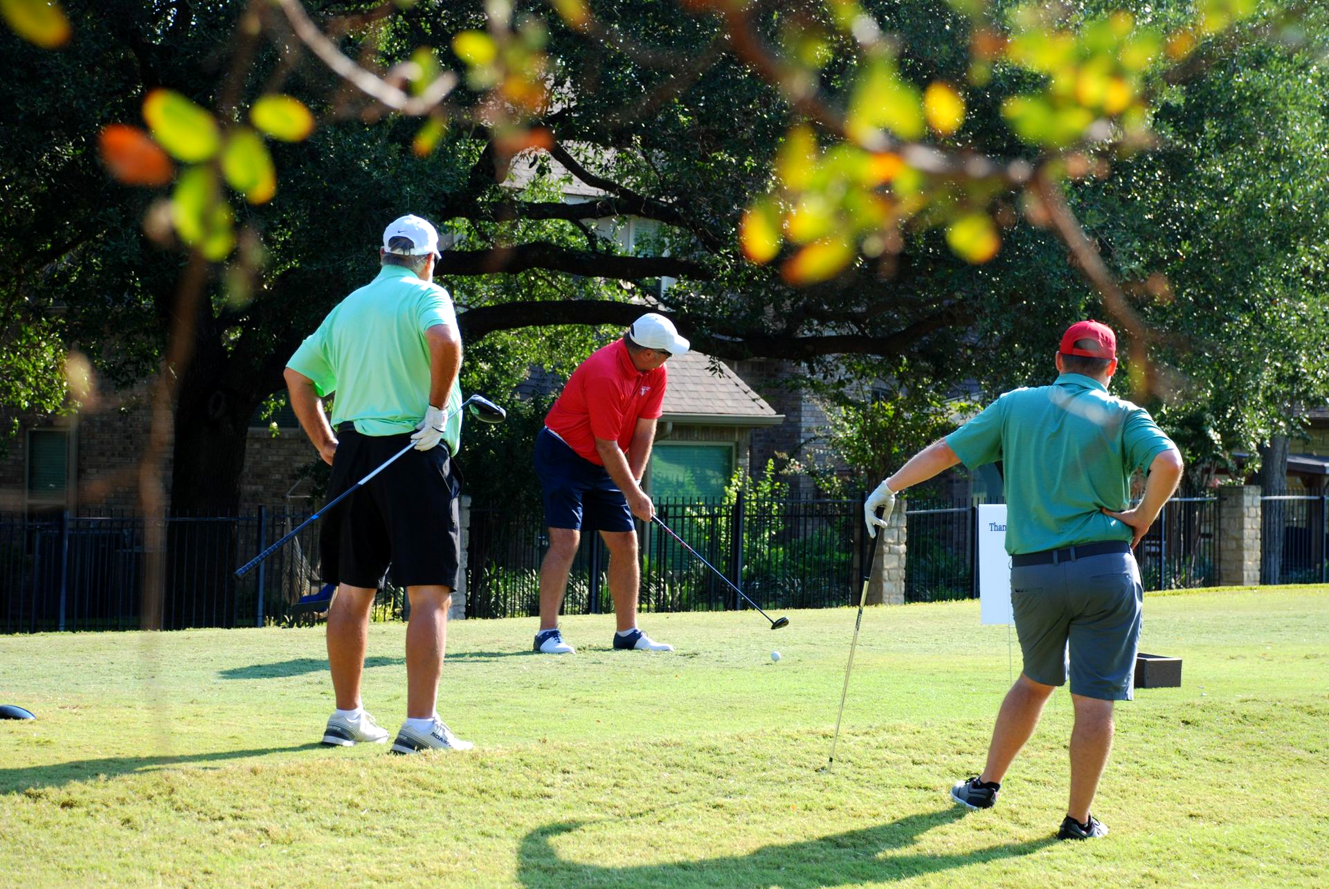 A bridge over a body of water leading to a golf course.