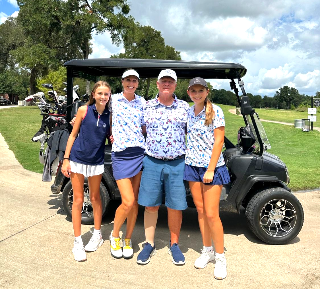 A group of people are posing for a picture on a golf course.
