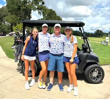 A group of people are posing for a picture on a golf course.