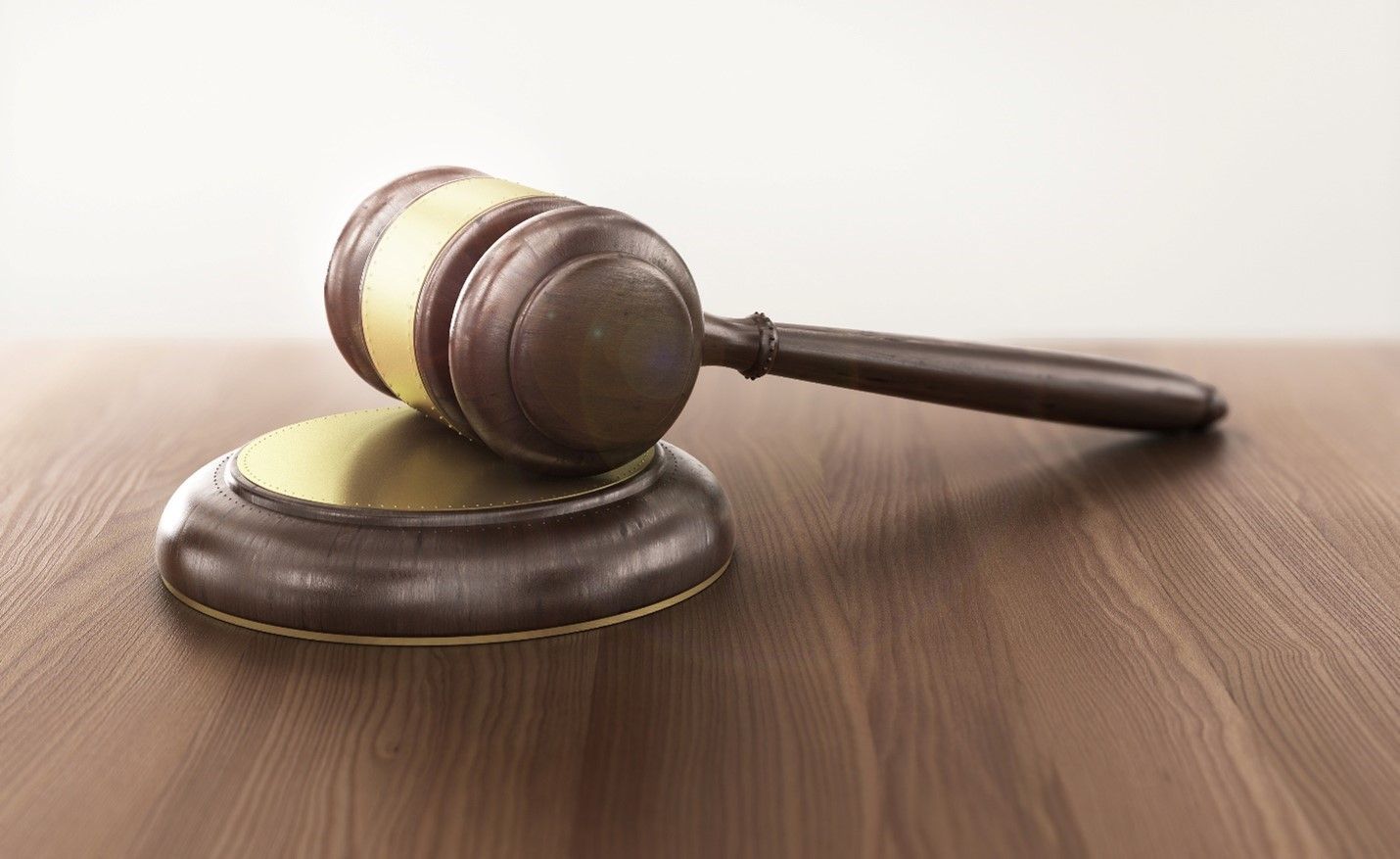 A wooden judge 's gavel is sitting on top of a wooden table.