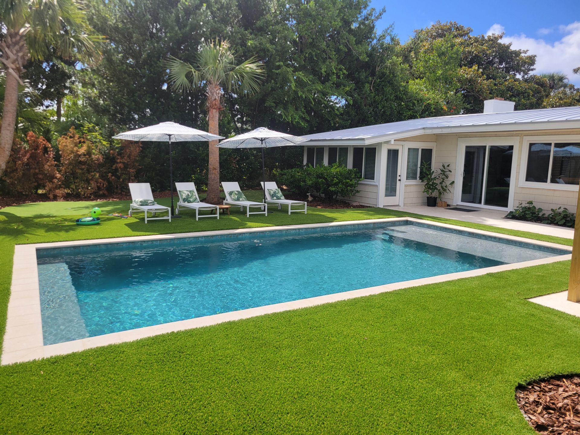 A large swimming pool in the backyard of a house