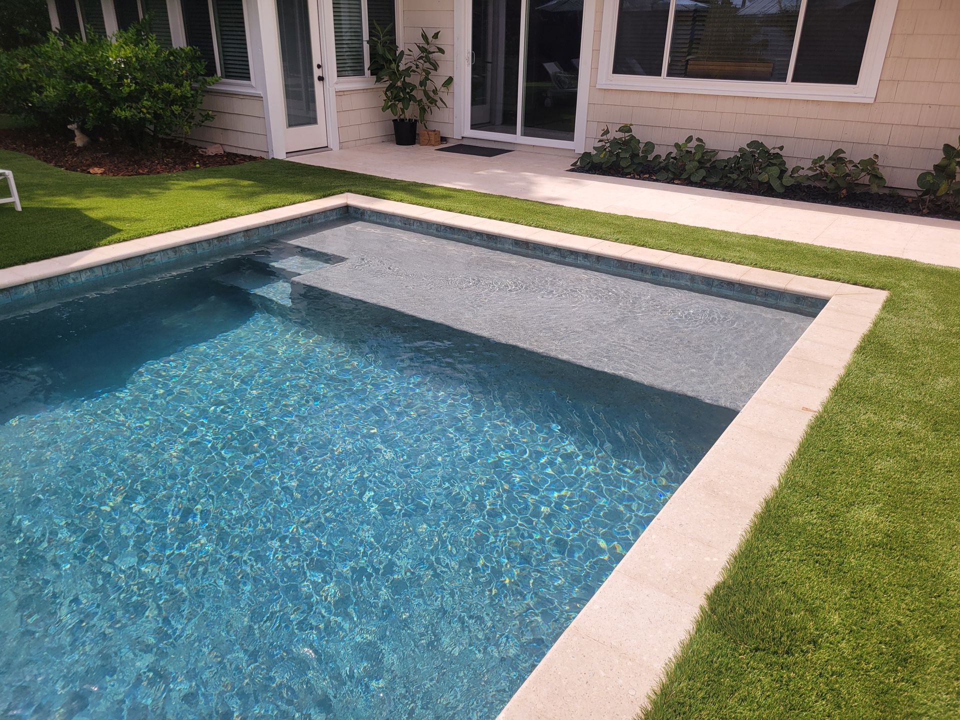 A large swimming pool in the backyard of a house