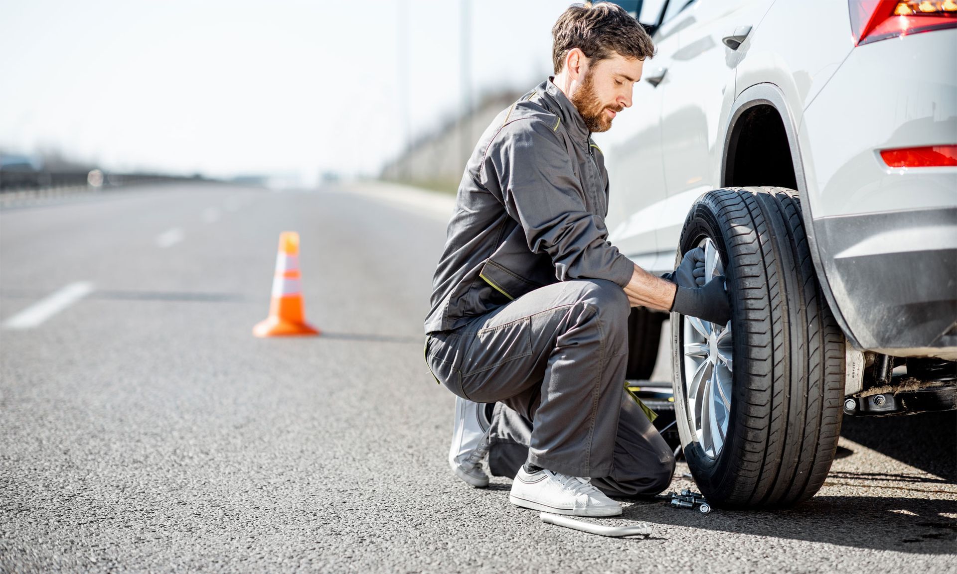 roadside technician removing flat tire