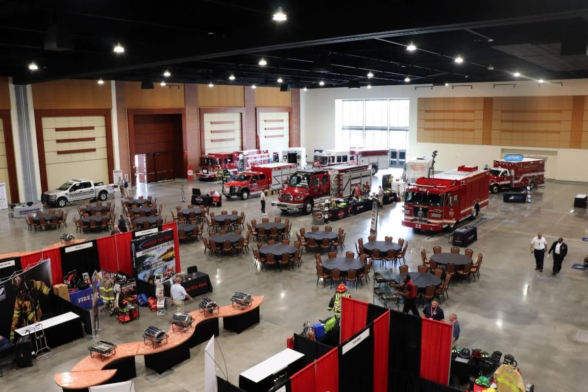 A large room filled with tables and chairs and fire trucks.