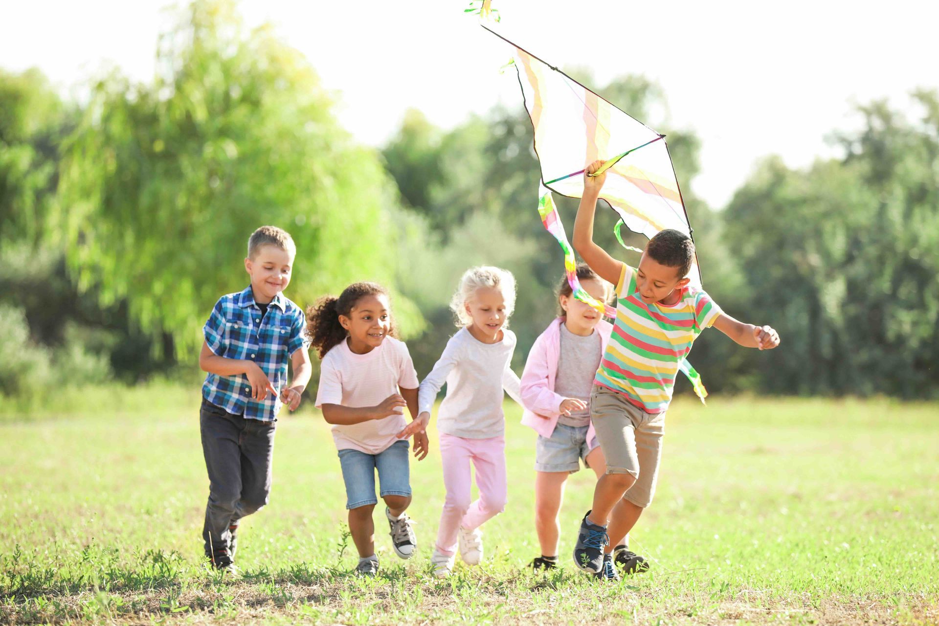 A group of children are flying a kite in a field.