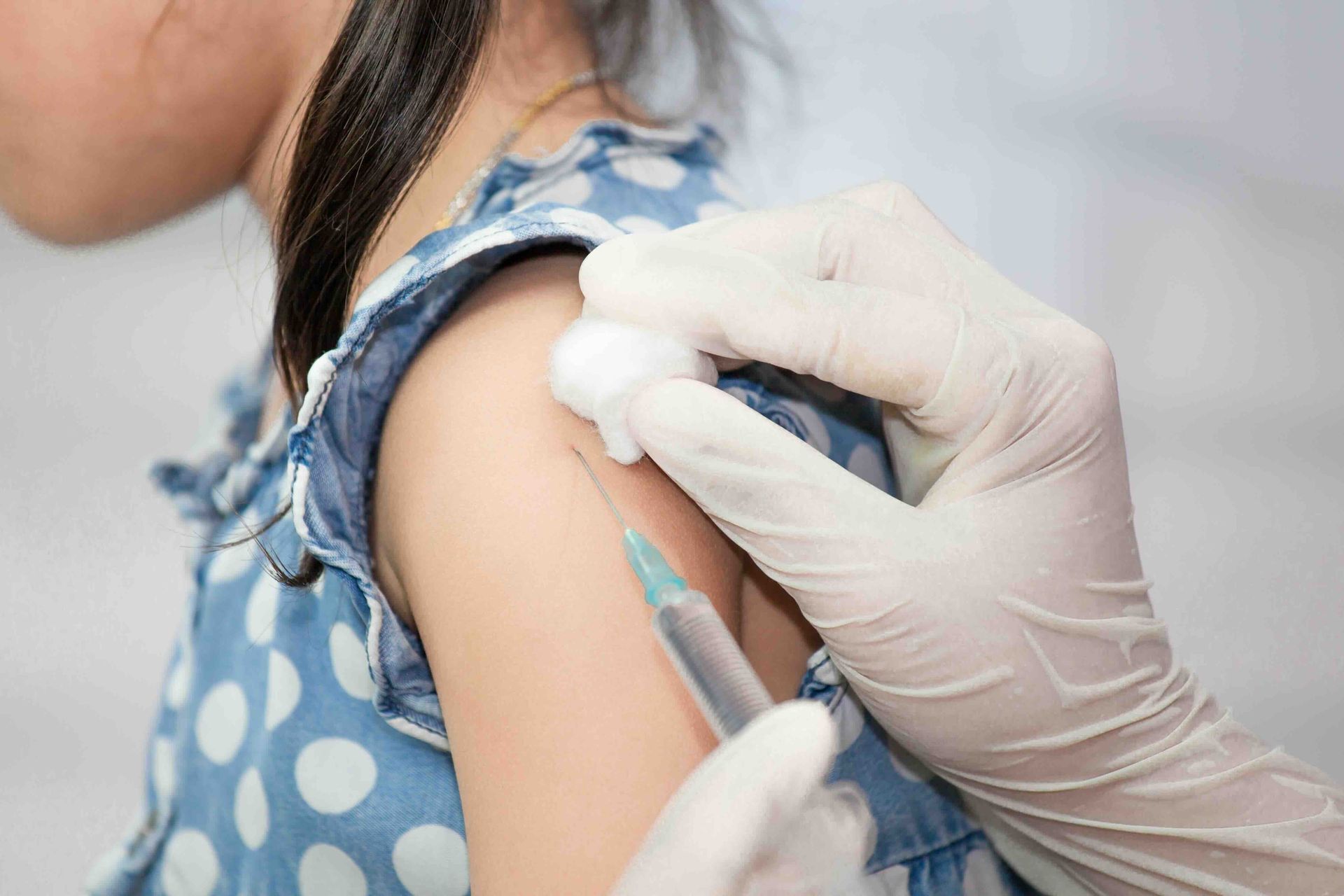 A little girl is getting an injection in her arm.