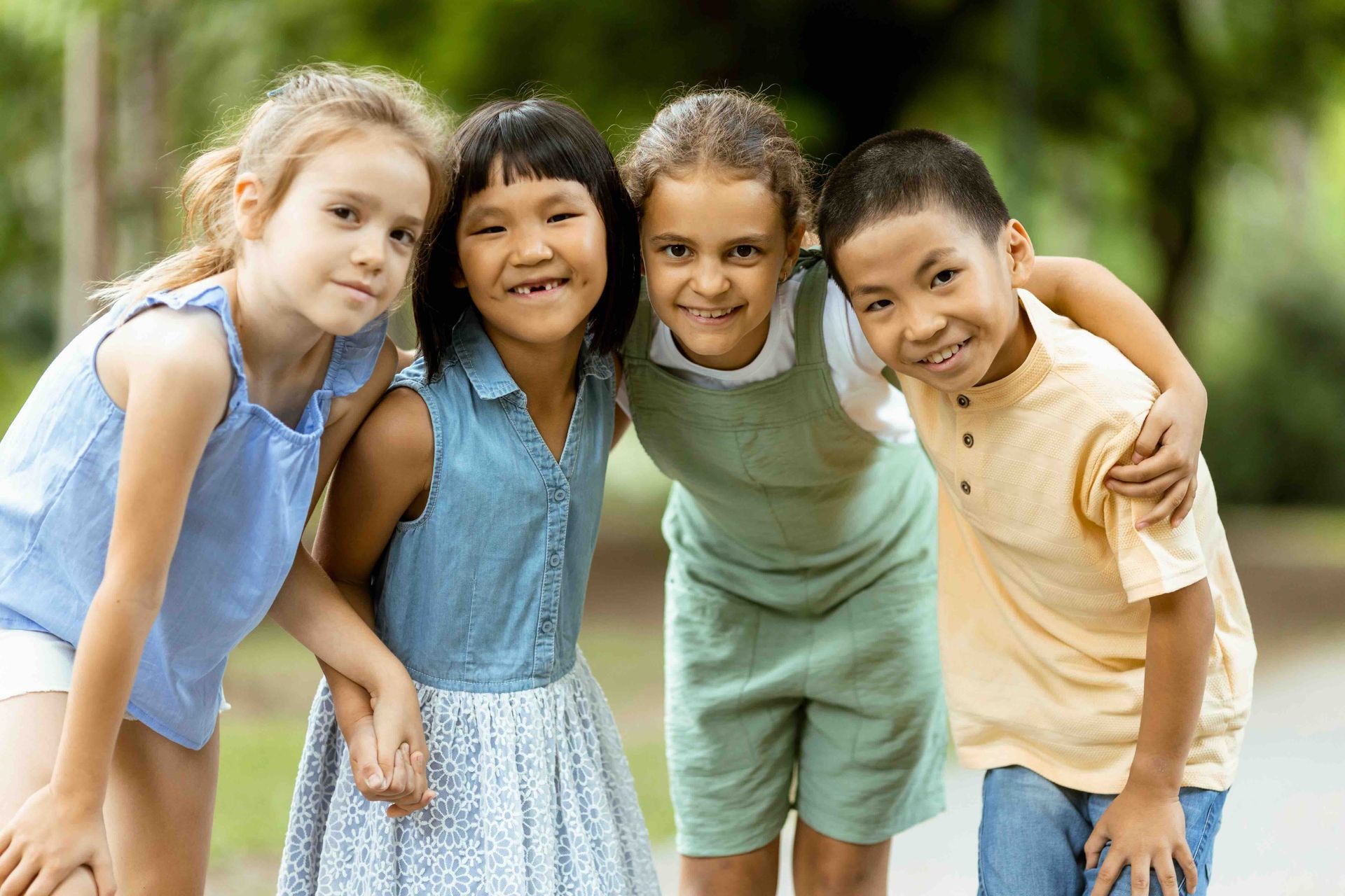 A group of children are posing for a picture together in a park.