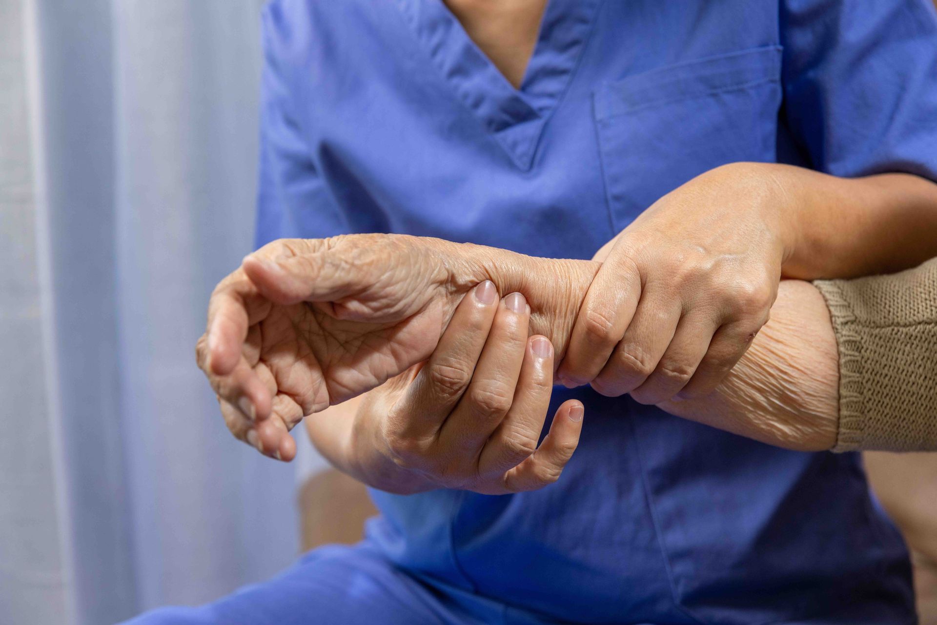 A nurse is taking the pulse of an elderly woman 's wrist.