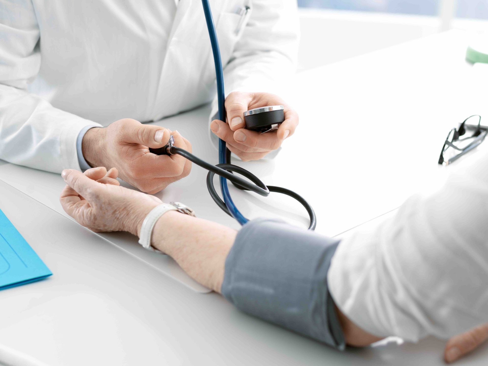 A doctor is checking an elderly woman's blood pressure.