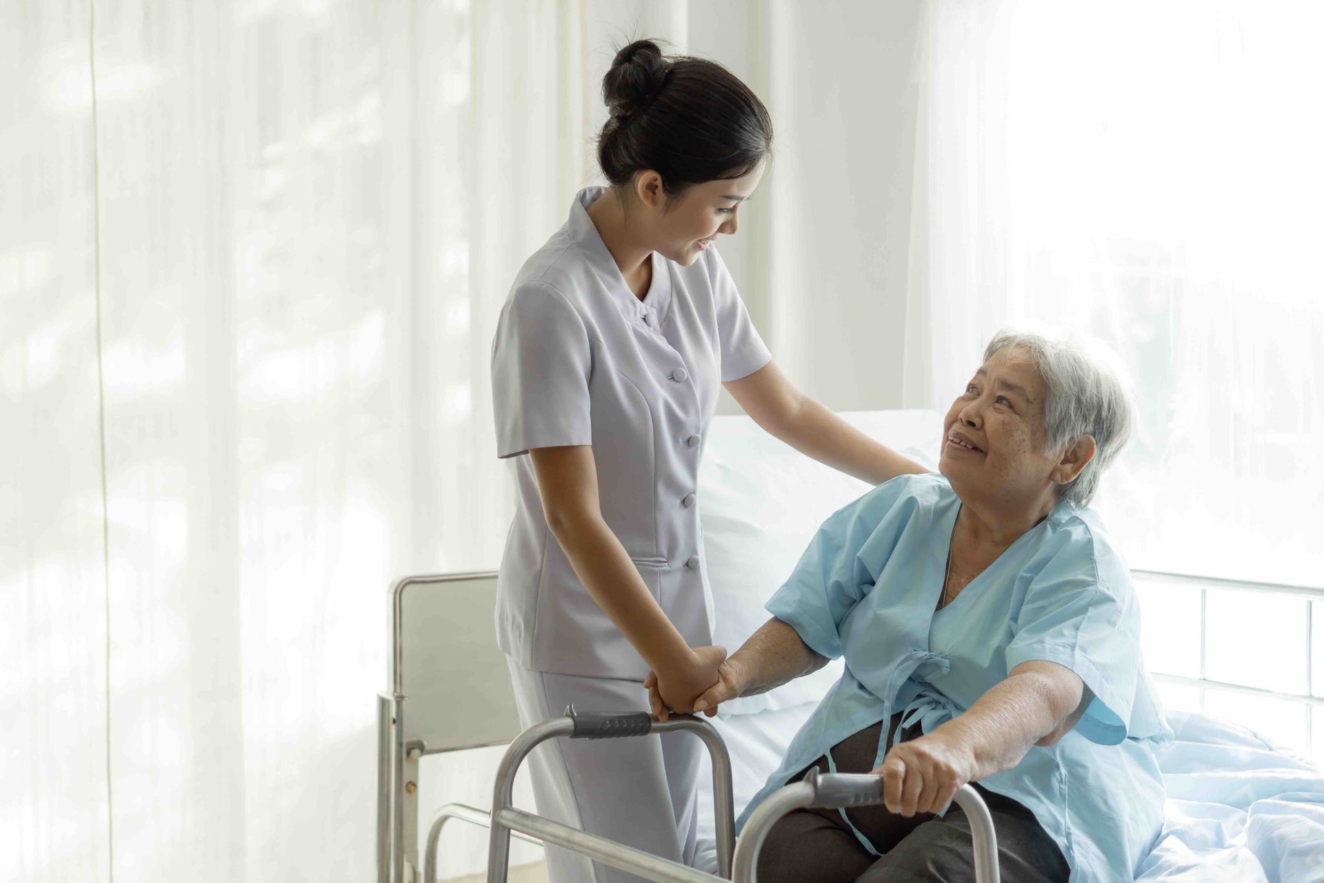 a nurse about to help an elderly women up from her bed